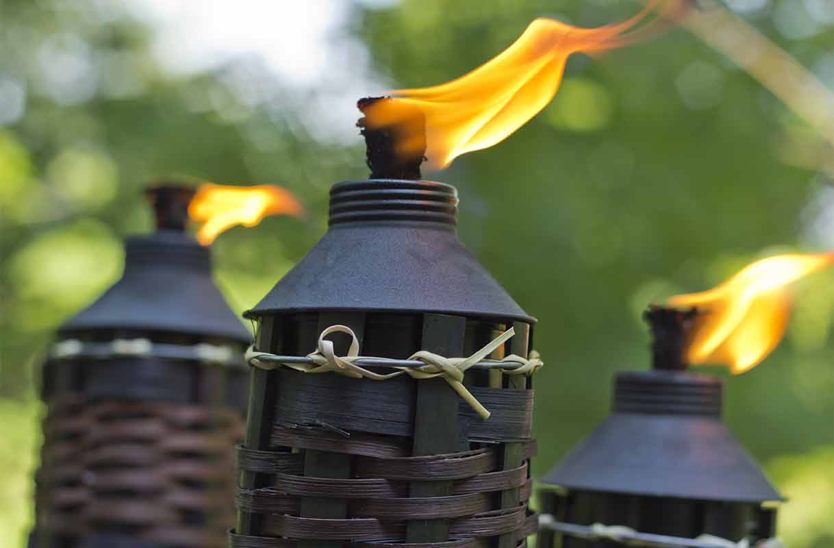 close-up of lit citronella tiki torch