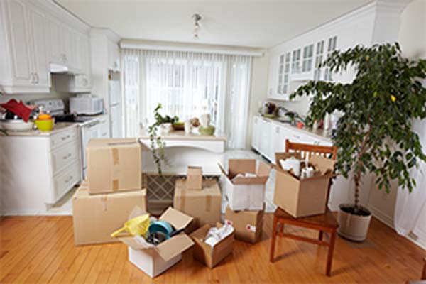 Pile of packed and unpacked moving boxes cluttering home interior